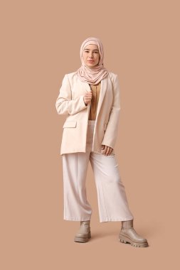 Kahverengi arka planda tesettürlü güzel Müslüman iş kadını