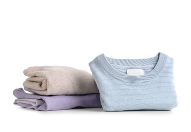 Beyaz arkaplanda izole edilmiş temiz elbise ve kazak yığını