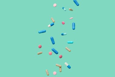 Turkuaz arka planda farklı haplar kullanılıyor.