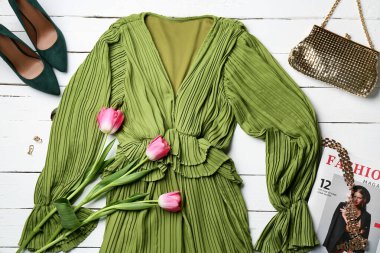 Şık kadın elbiseleri, lale çiçekleri, aksesuarlar ve hafif ahşap arka planda dergi kompozisyonu