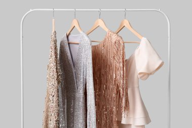 Gri arka planda askıda asılı güzel kadın elbiseleri