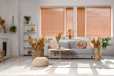 Rahat gri kanepesi, sehpası ve otları olan şık bir oturma odası.