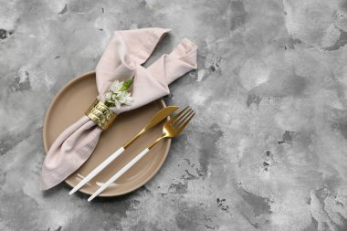 Altın çatal bıçak takımı ve gri grunge arka planında ornithogalum çiçeği olan güzel bir masa.