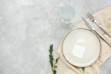 Boş kart ve gri arkaplanda okaliptüs dalına sahip güzel masa ayarları