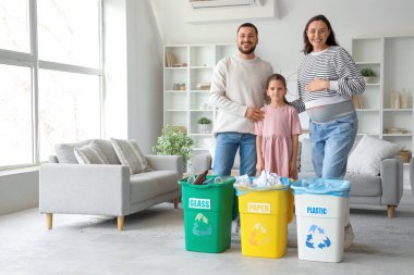 Evde çöp konteynırları olan bir aile. Küresel Geri Dönüşüm Günü