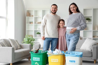 Evde kucak dolusu çöp konteynırları olan bir aile. Küresel Geri Dönüşüm Günü