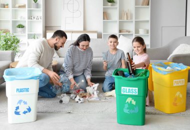 Evde çöp toplayan konteynırlı bir aile. Küresel Geri Dönüşüm Günü