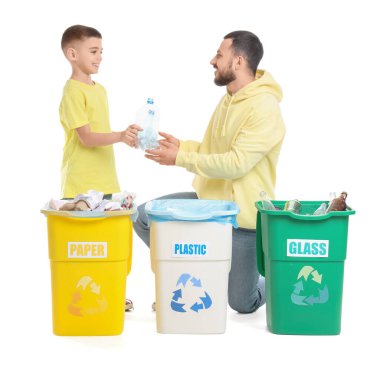 Babası ve oğlu beyaz arka planda çöpleri ayırıyor. Küresel Geri Dönüşüm Günü