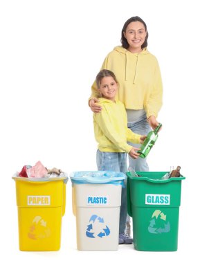 Kızına hamile bir anne beyaz arka planda çöpleri ayırıyor. Küresel Geri Dönüşüm Günü