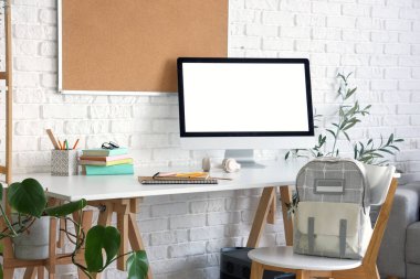 Sırt çantalı sandalye ve çocuk odasındaki boş bilgisayar monitörü.