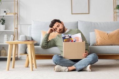 Evde kişisel eşyaları olan kovulmuş genç bir adam.