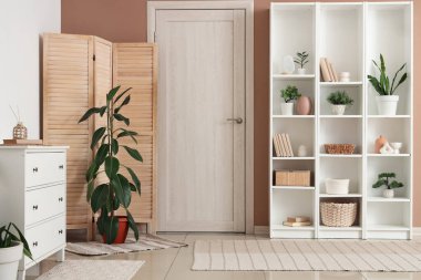 Çekmeceler, katlanan ekran ve raflar oturma odasının içinde.