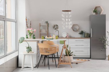 Paskalya için dekore edilmiş mutfak masası ve tezgahlarla süslenmiş.