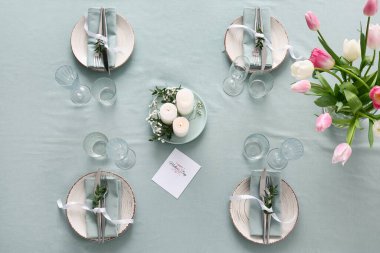 Anneler Günü kutlamaları için çok güzel bir masa. Yanan mumlar ve lale çiçekleri, yakın plan.