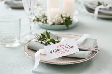 Anneler Günü kutlaması için güzel bir masa. Kutlama kartı ve mum yakma, yakın çekim.