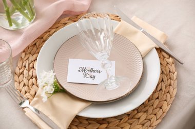 Anneler Günü kutlamaları için masa ayarlayın. Tebrik kartı ve güzel çiçeklerle, yakın plan.