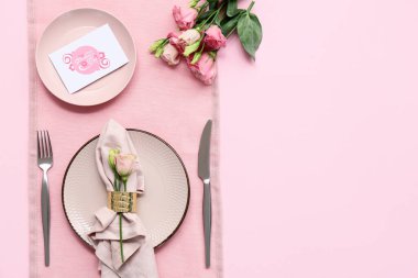 Tebrik kartı ve pembe arka planda Eustoma çiçekleri olan güzel bir masa. Anneler Günü kutlaması