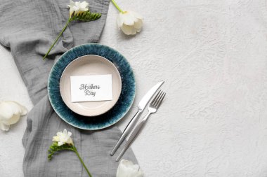 Tebrik kartı ve beyaz arka planda güzel çiçekler olan şık bir masa. Anneler Günü kutlaması