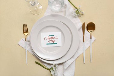 Tebrik kartı ve sarı arka planda güzel çiçekler olan şık bir masa. Anneler Günü kutlaması