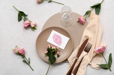 Tebrik kartı ve beyaz arka planda Eustoma çiçekleri olan güzel bir masa. Anneler Günü kutlaması