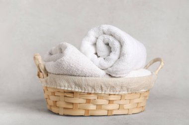 Arka planda temiz havlular olan hasır sepet.