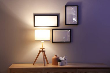 Parlayan lambalı çekmeceler ve karanlık odadaki boş çerçeveler.