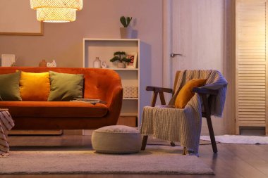 Akşamları koltuğu, koltuğu ve parlayan lambası olan oturma odasının içinde.