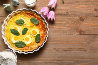 Lezzetli Paskalya yumurtalı tart ve ahşap arka planda lale çiçekleri.
