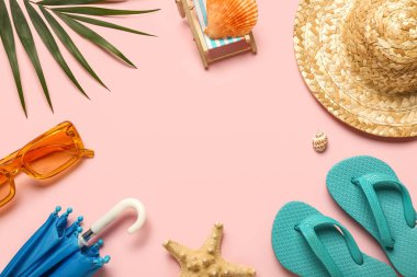 Mini plaj aksesuarları, güneş gözlükleri ve pembe arka planda palmiye yaprağından yapılmış çerçeve