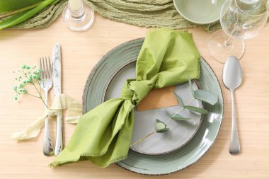 Güzel çiçekli şık bir masa, katlanmış peçete ve okaliptüs şubesi restoranın en üst katında.