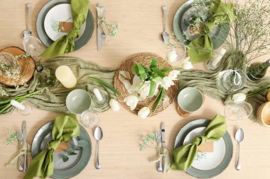 Güzel çiçekleri, mumları ve restoranda katlanmış peçeteleri olan şık bir masa.