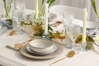 Restoranda güzel çiçekler ve mumlar olan zarif bir masa, yakın plan.