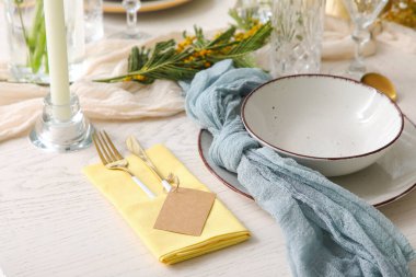 Restoranda güzel çiçekli ve altın çatal bıçaklı şık bir masa, yakın plan.