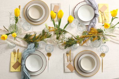 Restoranda güzel çiçekler ve mumlar olan şık bir masa, üst manzara.