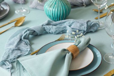 Altın çatal bıçak takımı, katlanmış peçete ve restoranda güzel çiçekler, yakın plan.