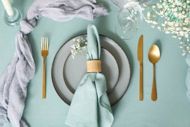 Altın çatal bıçak takımı, katlanmış peçete ve restoranda güzel çiçekler, üst manzara.