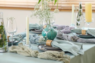 Güzel çiçekleri, mumları ve restoranda katlanmış peçeteleri olan zarif bir masa.