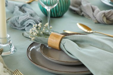 Altın çatal bıçak takımı, katlanmış peçete ve restoranda güzel çiçekler, yakın plan.