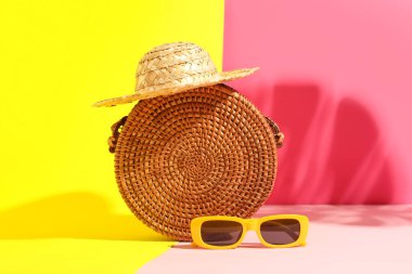 Şık bir kadın çantası, hasır şapka ve güneş gözlüğü.