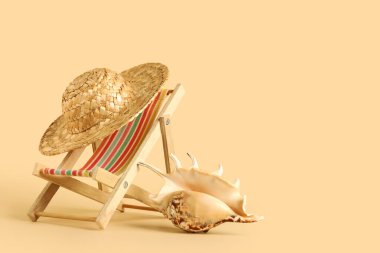 Mini iskemle, hasır şapka ve güzel deniz kabuğu.