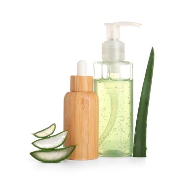 Beyaz arka planda kesilmiş aloe vera yaprağı olan farklı kozmetik ürünleri şişeleri