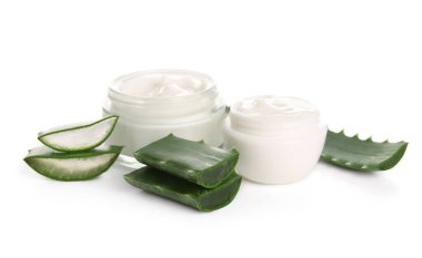 Beyaz arka planda kesilmiş aloe vera yapraklı kozmetik krem kavanozları.