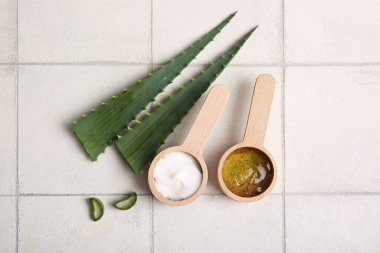 Ahşap kaşık kozmetik krem ve alüminyum vera yapraklı beyaz fayanslı jöle.