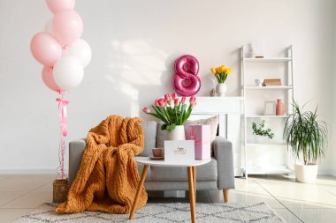 Kadınlar Günü için dekore edilmiş oturma odasının içi kanepe, masa ve balonlarla dolu.