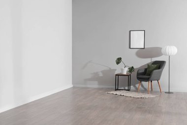 Oturma odasının içinde koltuk, masa ve lamba var.