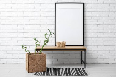 Hasır sepetin içinde masa ve bambu saplı şık bir oturma odası.