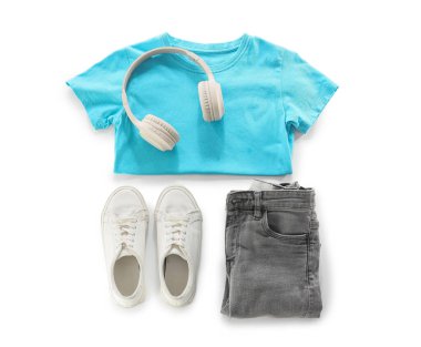 Beyaz arka planda şık çocuk kıyafetleri, ayakkabıları ve modern kulaklıkları olan kompozisyon