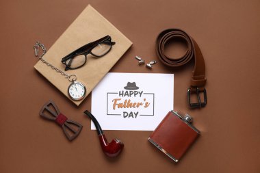 Mutlu Babalar Günü yazılı kart, şık erkek aksesuarları ve renkli arka plan kitabı