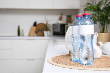 Mutfaktaki masada boş etiketli su şişeleri, yakın plan.