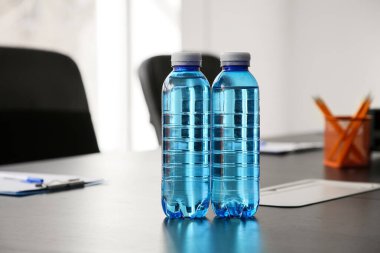 Modern ofisteki masada bir şişe su, yakın plan.